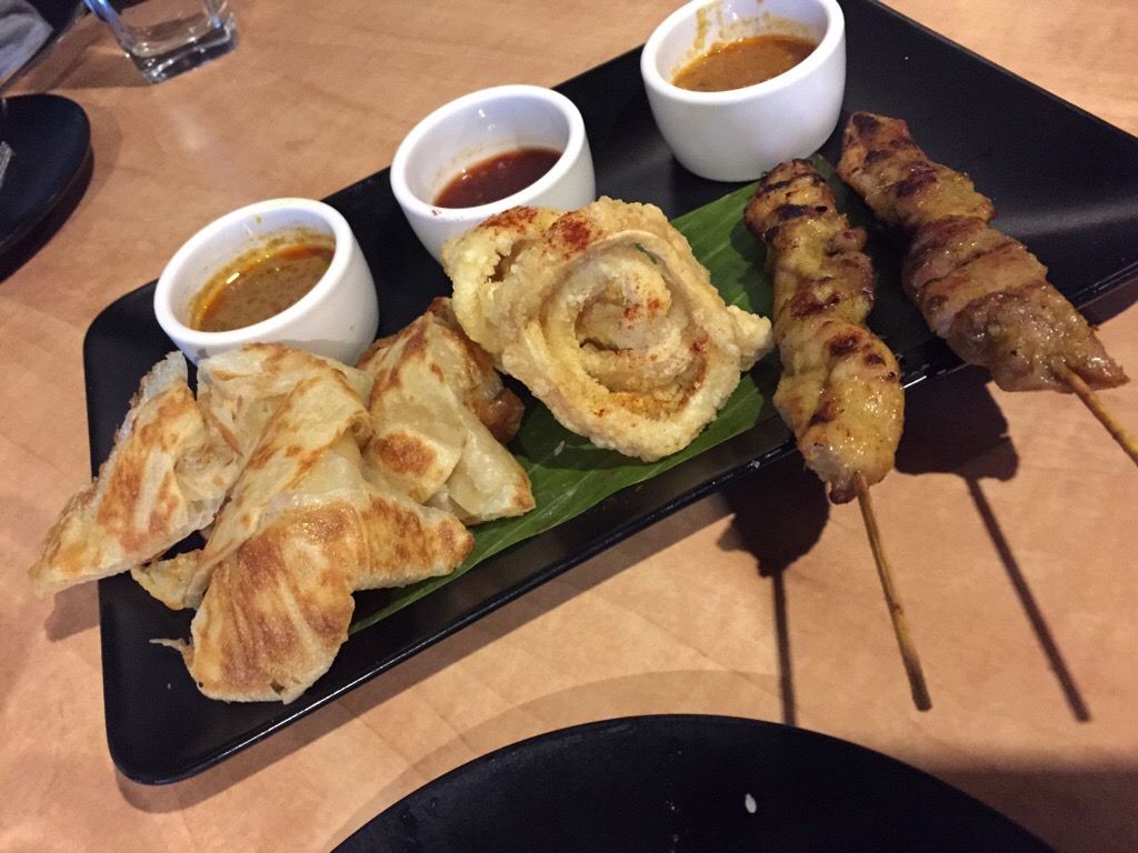 Rotti with curry dip, deep fried squid with chili sauce, and satay chicken skewer